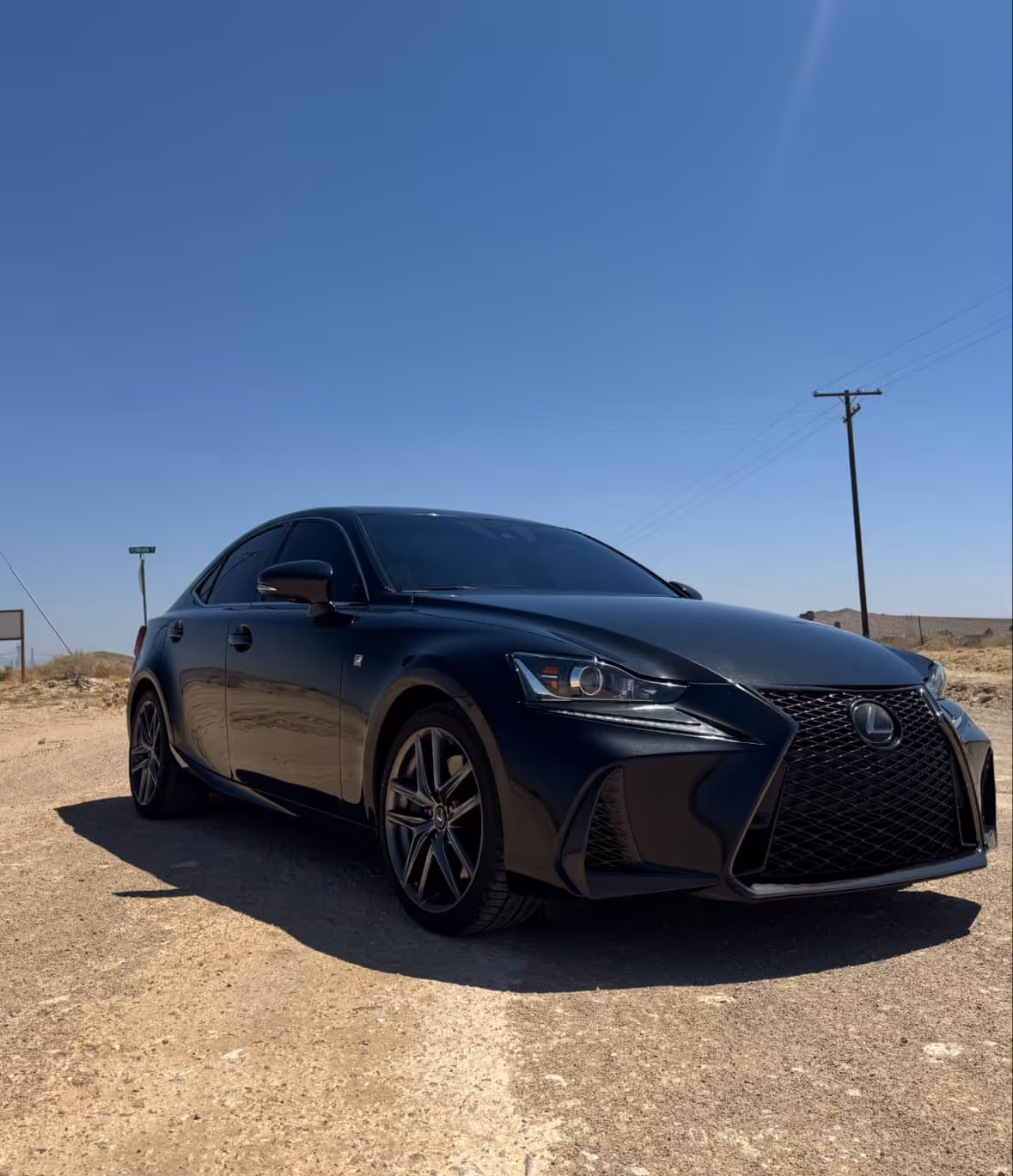 Blue Lexus IS sedan with ceramic window tint parked under clear sky