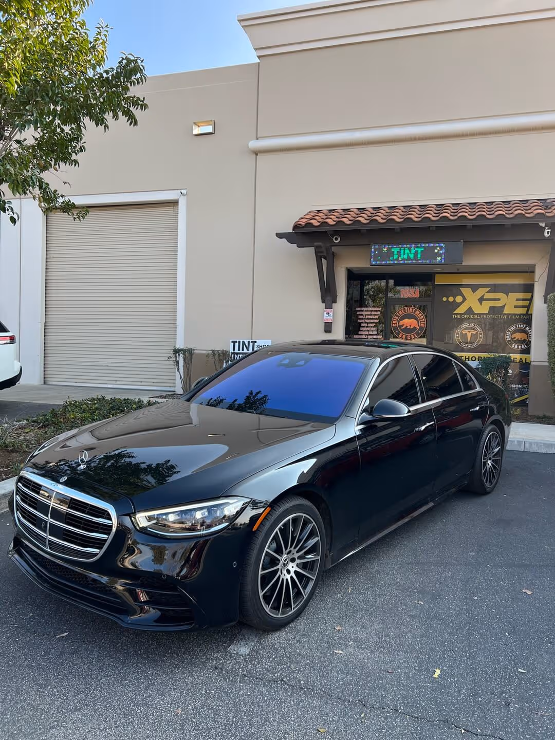 Black Mercedes-Benz sedan with glossy ceramic coating parked outside Tint Masters