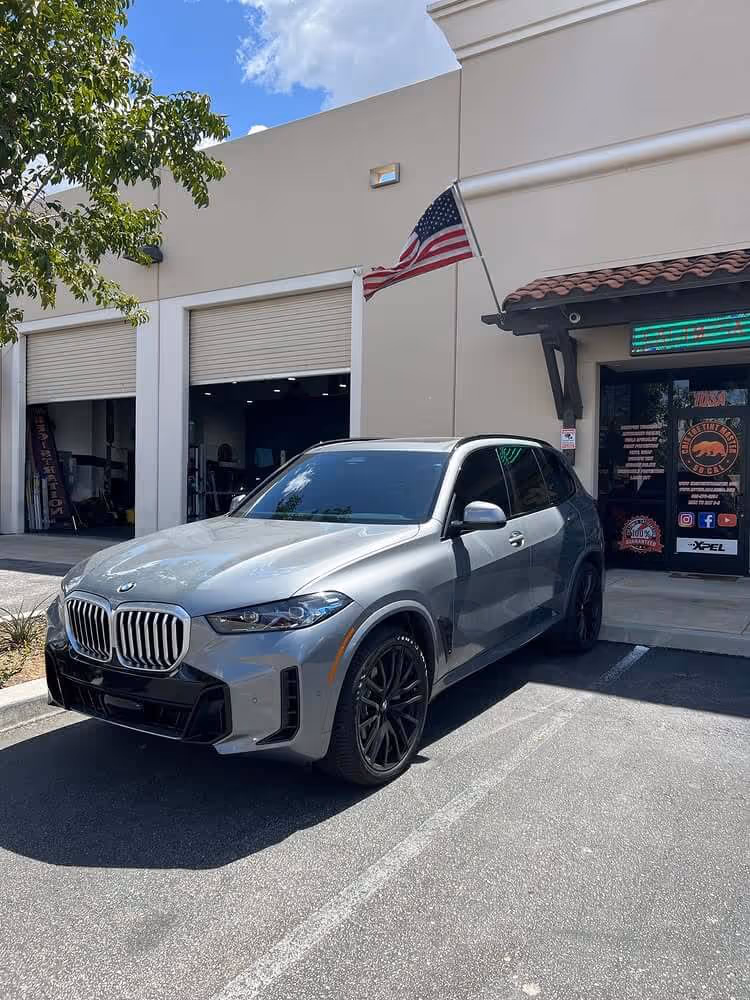 Gray BMW XM SUV with ceramic coating finish parked outside Tint Masters