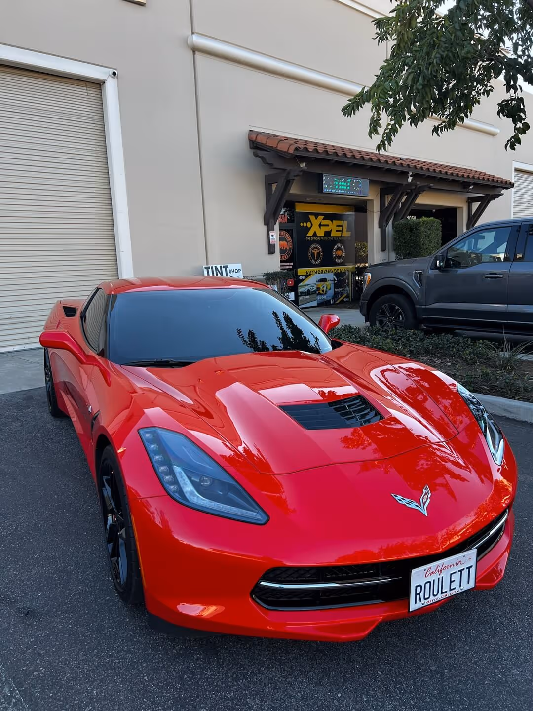 Red Chevrolet Corvette C7 with ceramic window tint parked outside Tint Masters