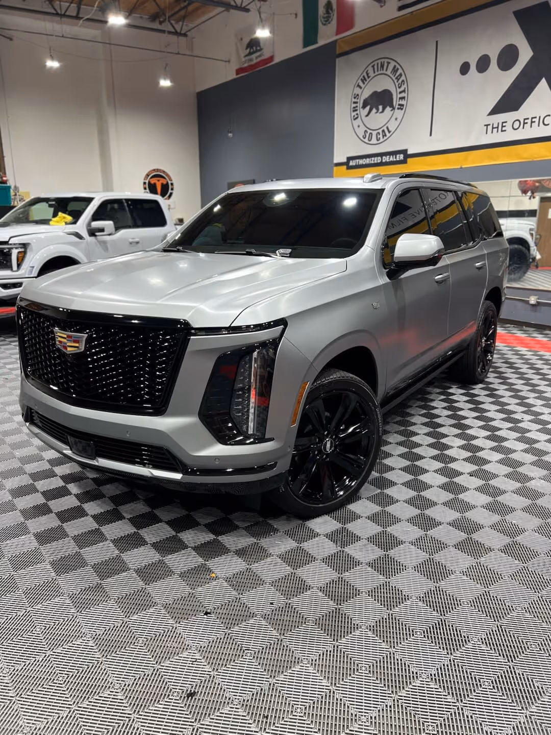Silver Cadillac Escalade with ceramic window tint inside Tint Masters installation bay